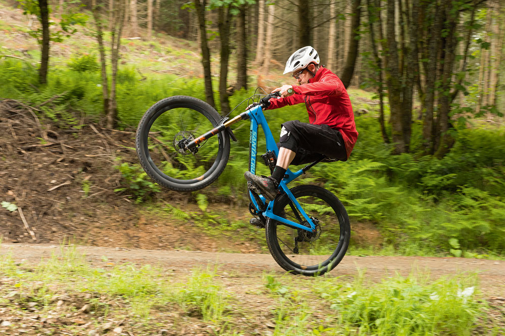 Pulling on the bars only makes it harder. Your weight will remain forward and the wheelie will feel heavy