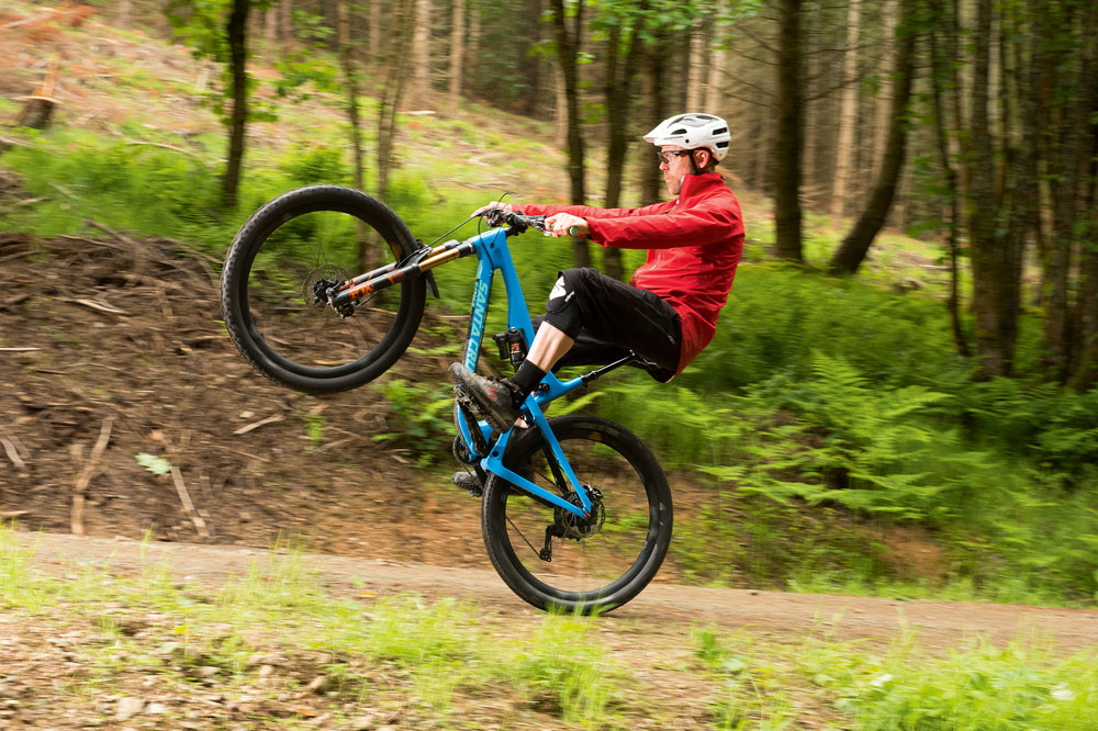 Staying seated and straightening your arms means that you can use your legs to accelerate your front wheel off the ground. Notice how Andy is sitting back and counterbalancing his front end by leaning back
