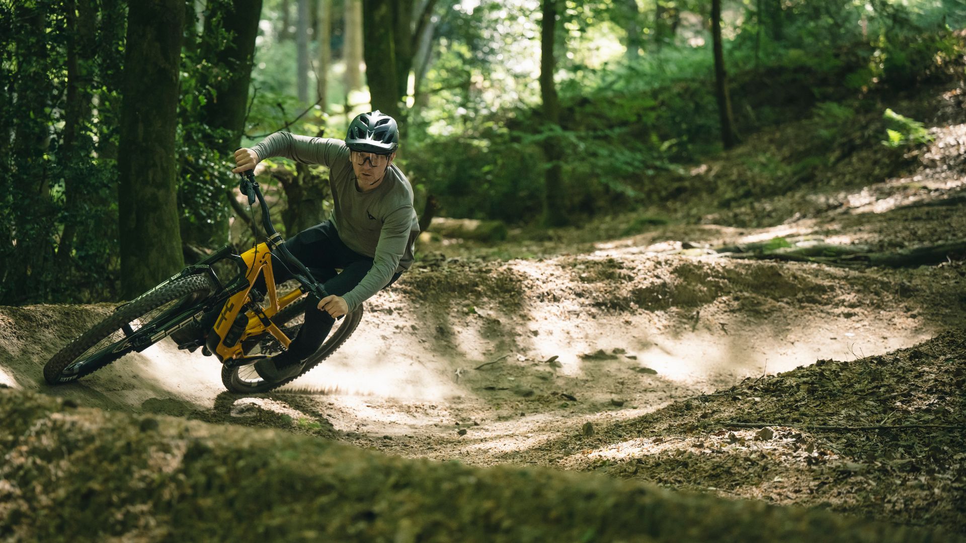 Man on mountain bike riding a berm - essential bike park skills