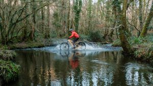 A cyclist riding through standing water.