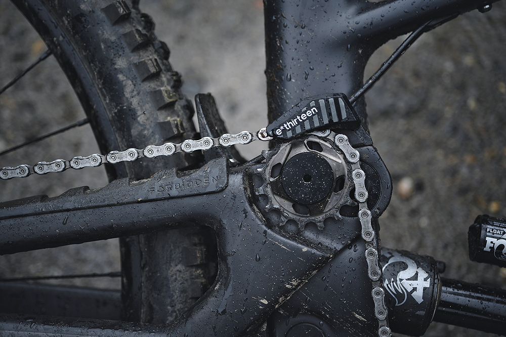 High-pivot idler design allows for rearward axle path while reducing pedal kickback