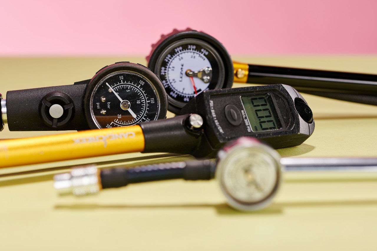 Selection of mountain bike shock pumps on a yellow table that were used in the MBR group test
