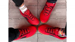 Four different feet each wearing a red Crank Brothers X Pump For Peace shoe
