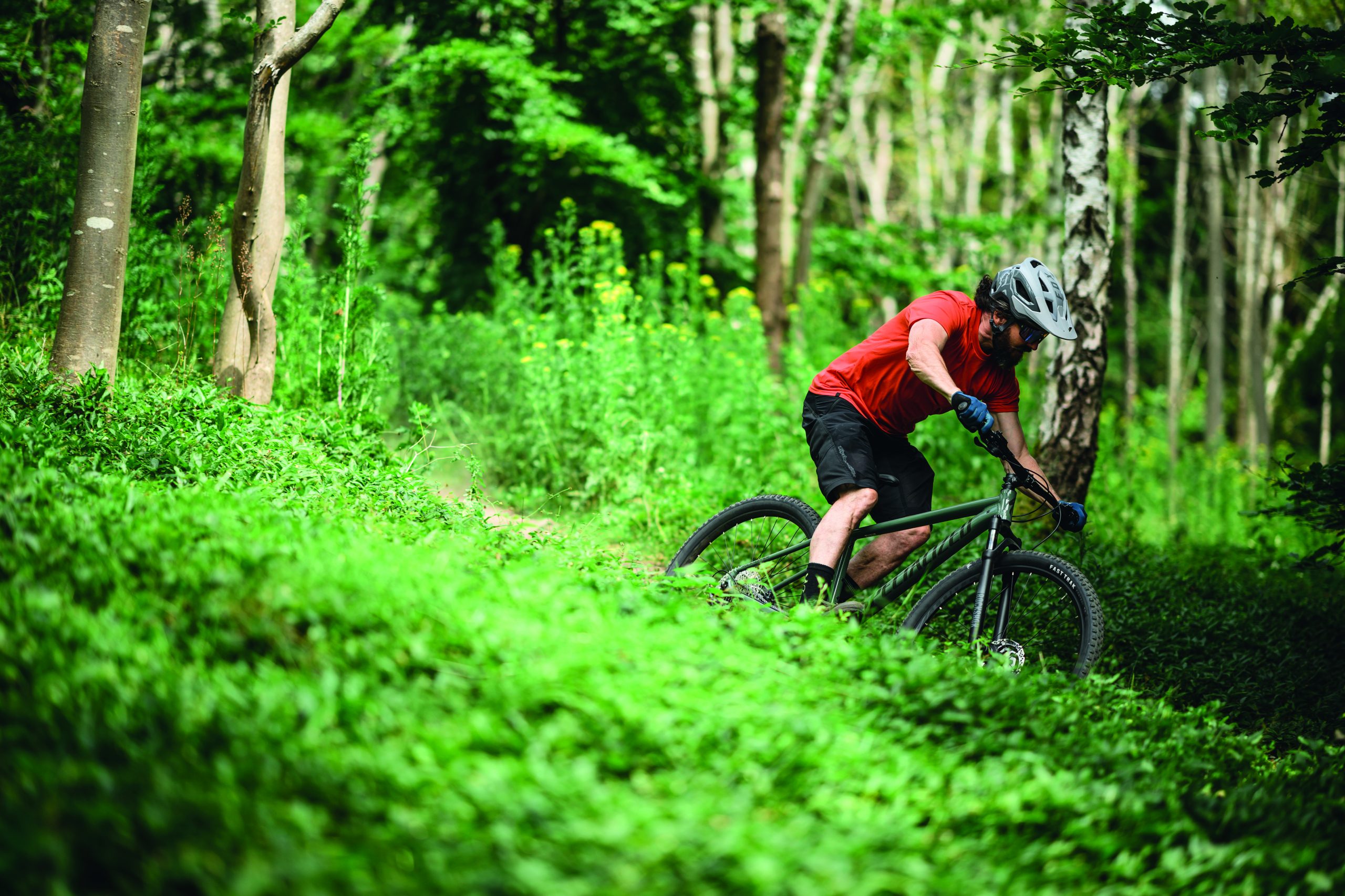 Image of mountain biker riding hardtail mountain bike through forest