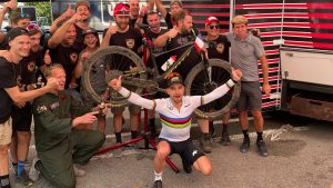 Nino schurter crouches in front of his Scott Spark mountain bike with a crowd standing behind him. The bike has new tech.