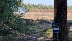 Fire burnt mountain bike trail in the Surrey Hills with Forestry England sign stating 'trail closed'