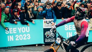 Crowd at Fort William with a board advertising the 2023 Glasgow Cycling World Champs