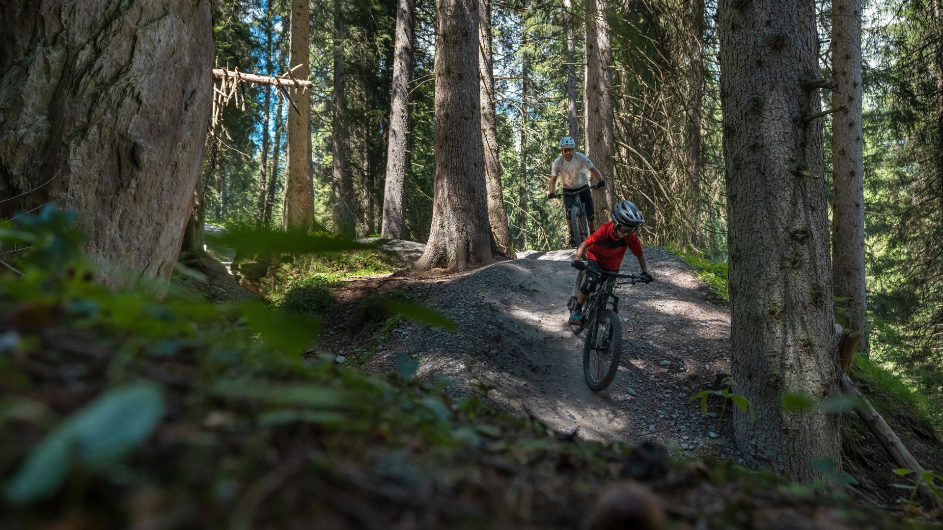 Boy riding the Specialized Levo SL Kids 2023 eMTB e-bike over rocks in a forest