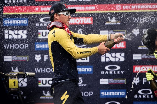 Loic Bruni sprays champagne on the podium of the Leogang 2024 World Cup Downhill