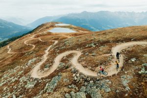 High Alpine singletrack berms, with three riders mountain biking