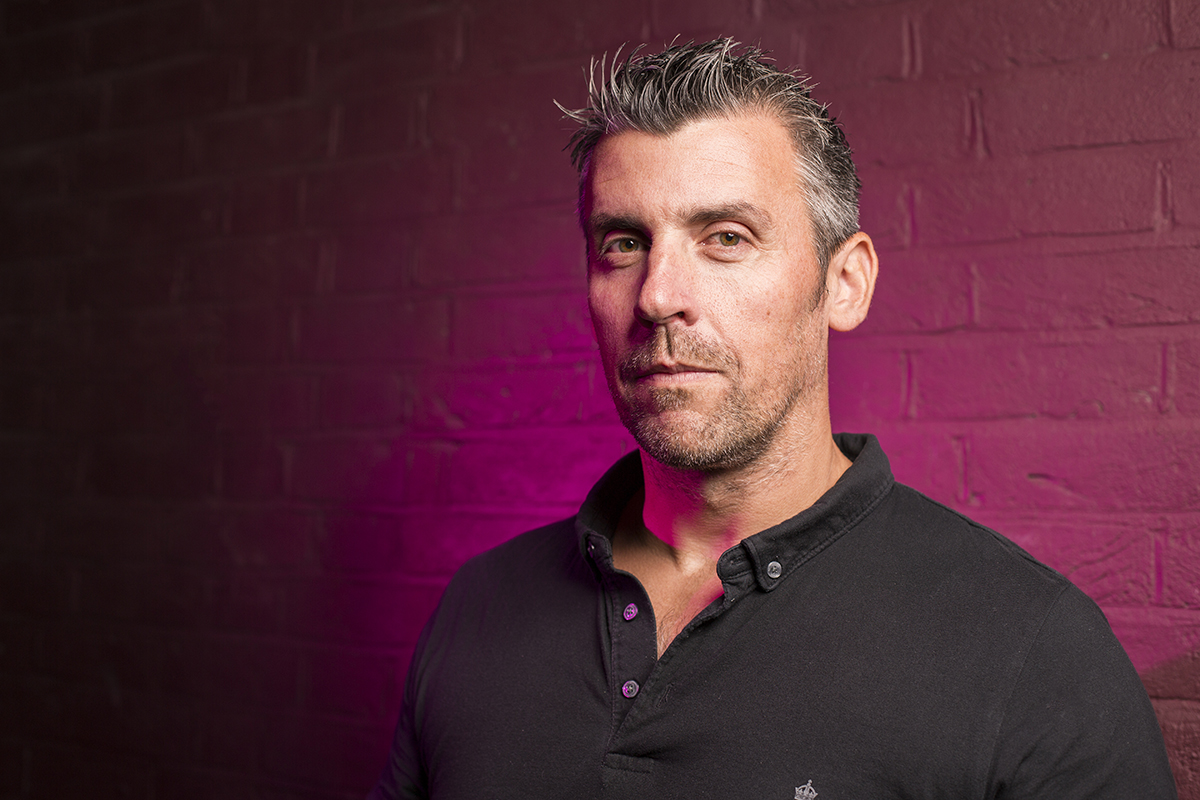 This image was taken with two Nissin Di700A units - one with a softbox positioned to the left and one with a spotlight grid and pink gel on the background