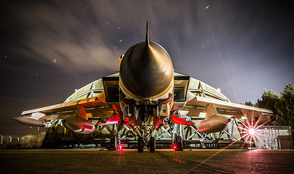 Twenty-five years since the Royal Air Force helped liberate Kuwait from Saddam Hussein's forces, an RAF Tornado GR4 has been painted in iconic Gulf War 'desert pink' paint scheme to honour the aircraft type's almost continuous operational service since then. The 'desert pink' Tornado, number ZG750, arrived at RAF Marham on the 30th March. The aircraft carries 11 'battle honours' on its tail, recalling the Tornado's almost continuous service on operations worldwide since 1991. This image was taken at night on the north east HAS Site at RAF Marham. Engineers were continuing to work on the aircraft throughout their night shift in preperation for scheduled maintenance. This maintenance would be vital in ensuring the Jet is fully serviceable for several public events it is due to make an appearance at. SAC Rose Buchanan is an RAF Photographer and is currently based at RAF Marham. She joined the RAF in 2014 to pursue an adventurous and fulfilling career in the military. Following completion of the Defence Photographer course at RAF Cosford in September 2015, she began her first posting at RAF Marham. Air Vice-Marshal Gary Waterfall, who is responsible for RAF strike aircraft as Air Officer Commanding 1 Group RAF, said: "The Royal Air Force can look back at Tornado's service on Operation Granby with great pride. In the 25 years since the Gulf War, Tornado has proven itself again and again to be a formidable strike aircraft with an enviable operational record; today it continues to serve the nation in the fight against Daesh." The Tornado was introduced into RAF service in 1979, and has been updated throughout its life to keep up with the changing requirements of the modern battlefield. Today's Tornado GR4s carry improved precision guided weapons including the Paveway IV laser- or GPS-guided bomb and brimstone missiles, as well as cutting-edge RAPTOR and litening III surveillance and targeting pods. RAF Marham was delighted to welcome the arrival of the unique and ico