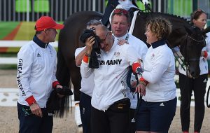 Groom Robbie Sanderson being helped from the team dressage medal ceremony