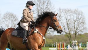 Girl riding horse with a five-point breastplate