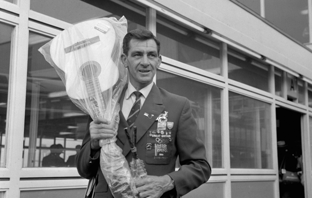 Staff-Sergeant Ben Jones, a member of the British Olympic equestrian team, who gained a gold medal at the Olympic Games in Mexico, on their return at Heathrow Airport, London. Ben also brought back some souvenirs - a guitar and a sombrero.