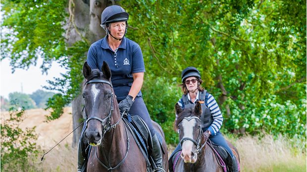 JW9HAC Two ladies out riding horses on a summers day