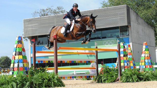 Nick Skelton riding Big Star soring over an orange oxer fence at the Rio Olympics
