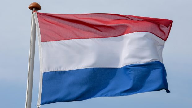 WK7R9D Dutch flag waving on the wind against blue sky