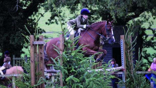 Susie Eddis and Beat The Boss jump a rustic spread at the Royal International