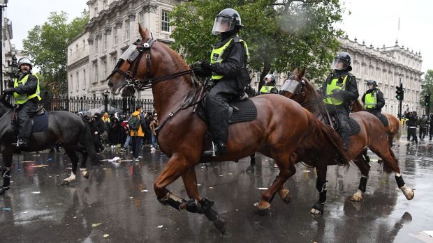Mounted police officers charge their horses along Whitehall, past the entrance to Downing Street, in an attempt to disperse protestors gathered in central London on June 6, 2020, during a demonstration to show solidarity with the Black Lives Matter movement in the wake of the killing of George Floyd, an unarmed black man who died after a police officer knelt on his neck in Minneapolis. - The United States braced Friday for massive weekend protests against racism and police brutality, as outrage soared over the latest law enforcement abuses against demonstrators that were caught on camera. With protests over last week's police killing of George Floyd, an unarmed black man, surging into a second weekend, President Donald Trump sparked fresh controversy by saying it was a 