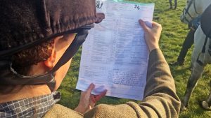 An event rider reading their dressage score sheet