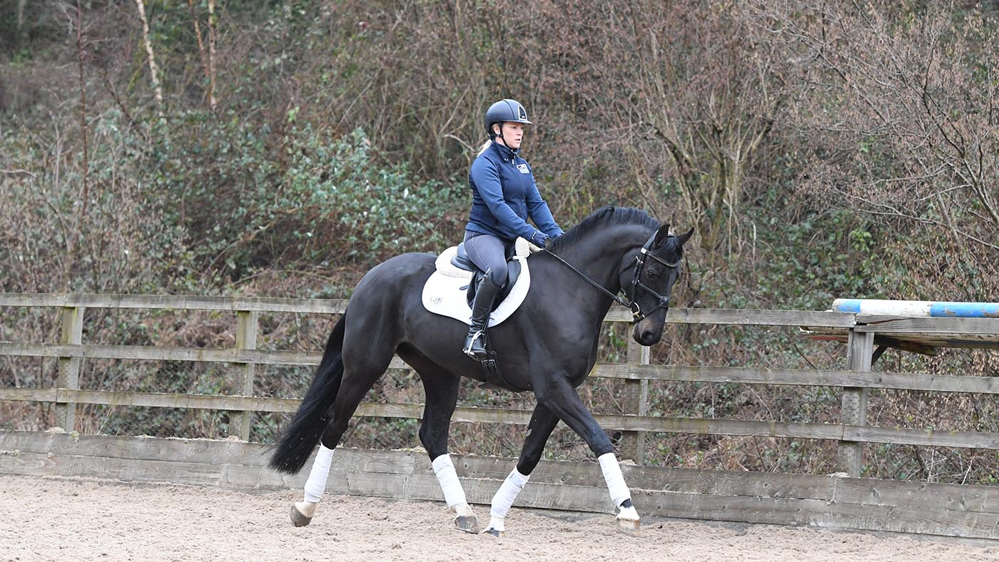 Vicky Tuffs riding Kojak (Black gelding) in the large all-weather areas nestled in the valley below GHF Equestrian yard at Great House Farm near Usk in Monmouthshire in Wales on the 10th January 2021