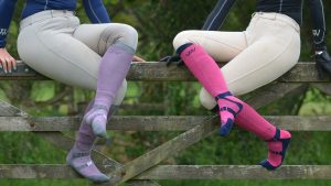 Two riders wearing the Woof Wear Long Bamboo Waffle Riding Sock