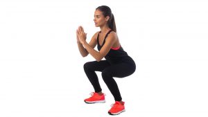 2CH18G4 Healthy hispanic fitness girl with doing workout squat exercise isolated on white background