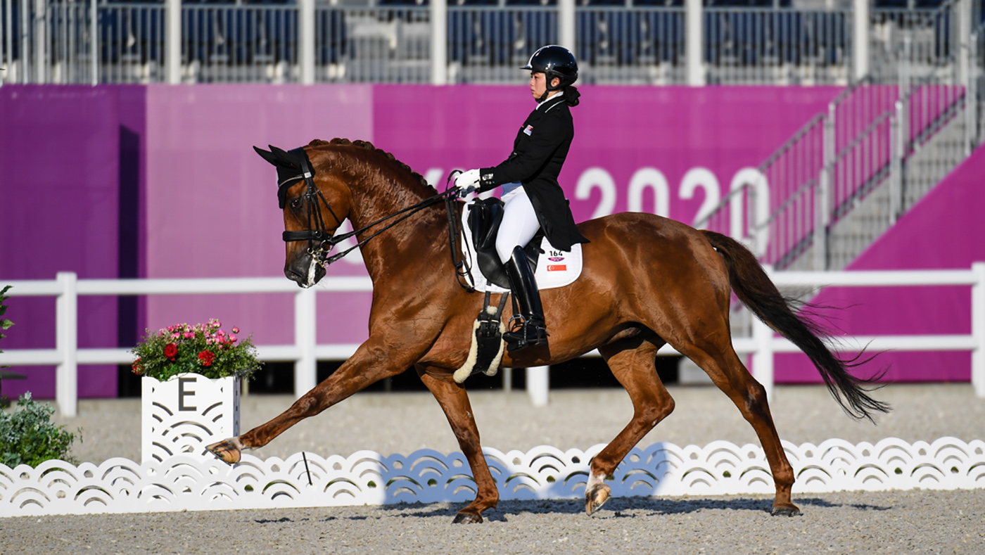 Caroline Chew riding Tribiani in the grand prix at the Tokyo Olympics, before being eliminated under the blood rule