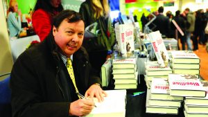 2BAABPG Bloodline author Felix Francis signs copies of his books at Sandown Park.