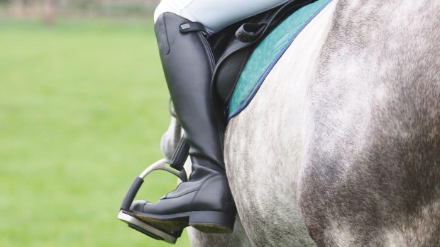 Rider in saddle wearing long boots