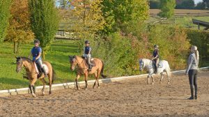 Three beginner riders having a lesson with an instructor