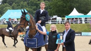 Paul Sims and Dream Roller win the CSI3* 1.50m grand prix qualifier, while wearing orange ribbons, at Bolesworth International Horse Show