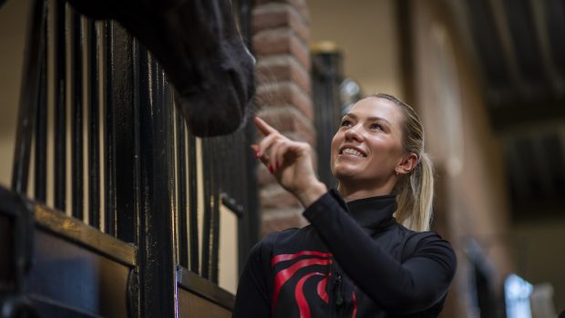 World champion Lottie Fry pictured stroking the nose of one of the horses at the van Olst’s indoor yard in the Netherlands