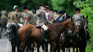 Rider drinking out of hip flask on horseback