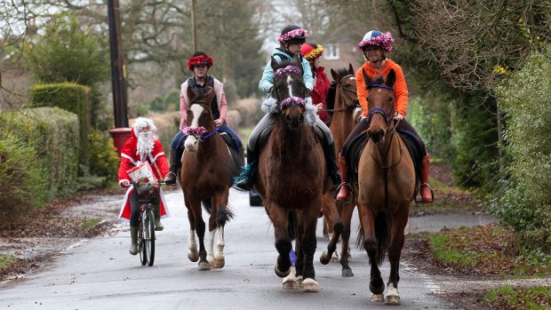 Horse riders dressed Christmassy with Santa on a bike
