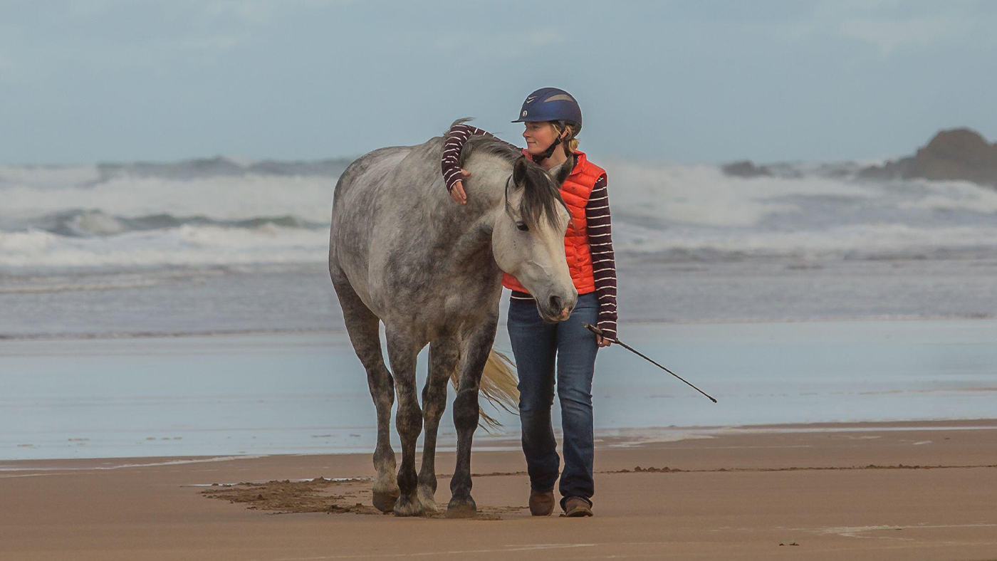 Emma Massingale entrenando en libertad con su caballo en la playa