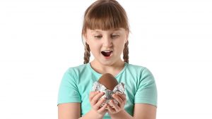 Surprised little girl with chocolate Easter egg