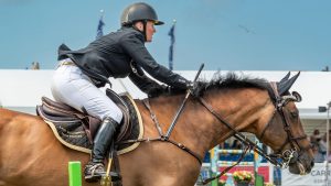 Showjumper carrying a BS legal whip over fence