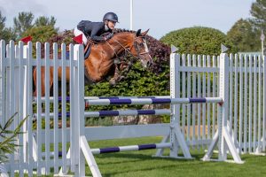Lauren Wilkins jumps a fence on Eloclea Ro. Del Colle San Marco in the The Oakley Coachbuilders Bs Winter Grade Jc Championship at The Longines Royal International Horse Show, The All England Jumping Course, Hickstead