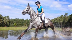 Girl riding cross-country wearing one of the best jockey skulls