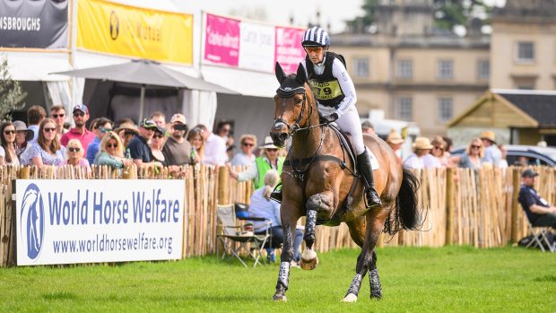 Caroline Powell and Greenacres Special Cavalier gallop past the crowds at the Lake with Badminton House in the background.