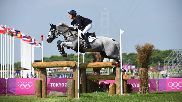 Christopher Six of France jumping an open oxer on the cross-country course at the Tokyo Olympics while riding grey horse Totem De Brecey.