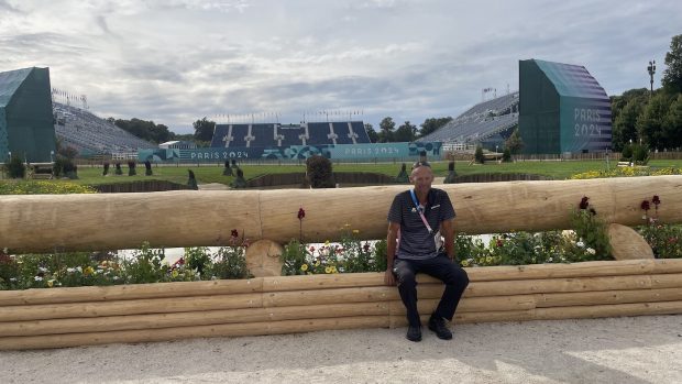 Pierre Le Goupil sits on a fence on the Paris Olympics cross-country course