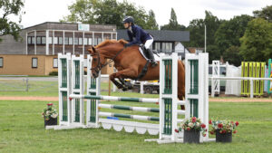 Rachel Davis and Benate jump an oxer on grass at the British Showjumping National Championships.