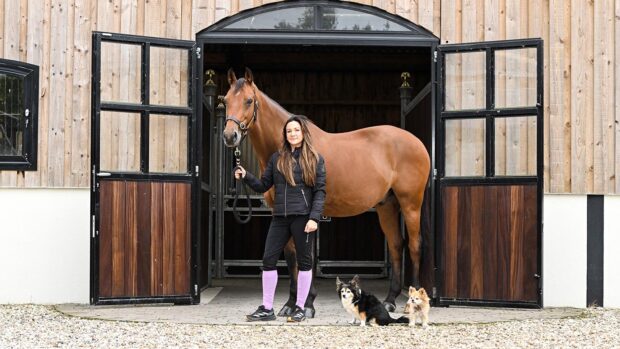 Abi Lyle with Giraldo and her dogs Squidge and Abu at her yard, Chimneys, in Stretton-on-Fosse near Moreton-in-Marsh in Gloucestershire