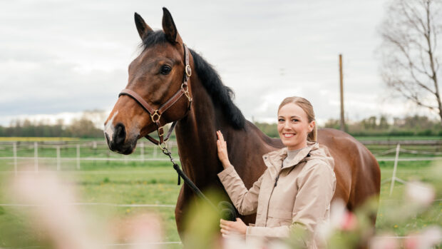 Woman wearing lightweight jacket holding horse