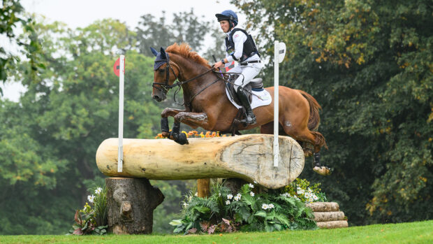 Tom McEwen and CHF Cooliser jump the solid corner at the Diary Mound on the Defender Burghley cross-country course 2024.