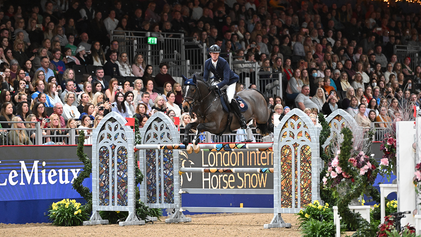 Ben Maher and Sentimiento LS la Silla clear a large oxer in front of packed stands at the London International Horse Show.