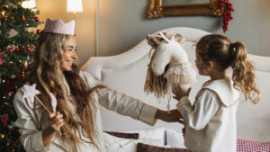 Children playing with hobby horse gift with Christmas tree in background